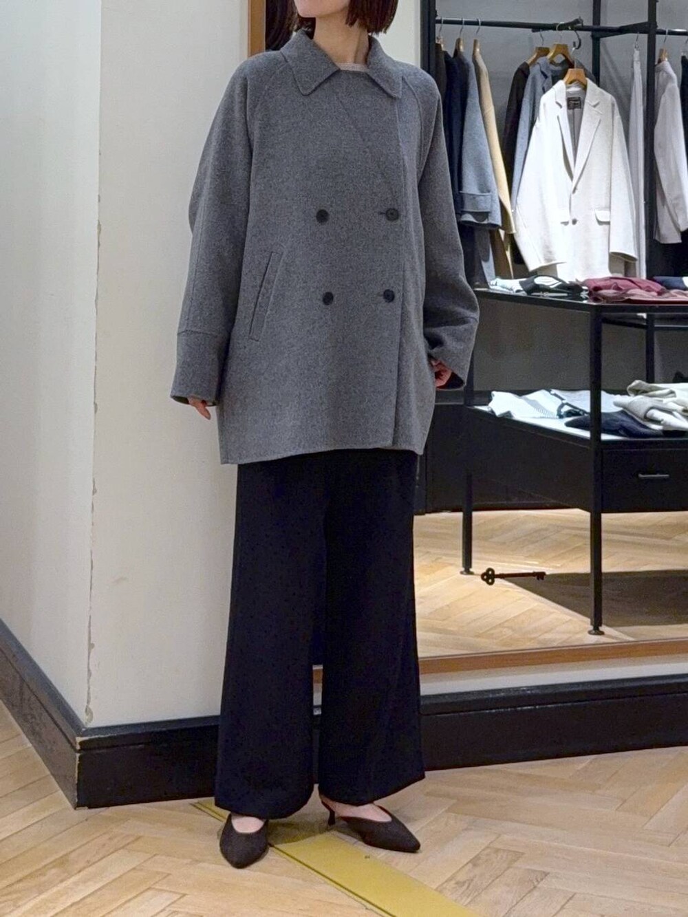 グレー系のその他アウター、ホワイト系のニット/セーター、ブラック系のスラックスを着用したレディースの秋コーディネートの4枚目の写真