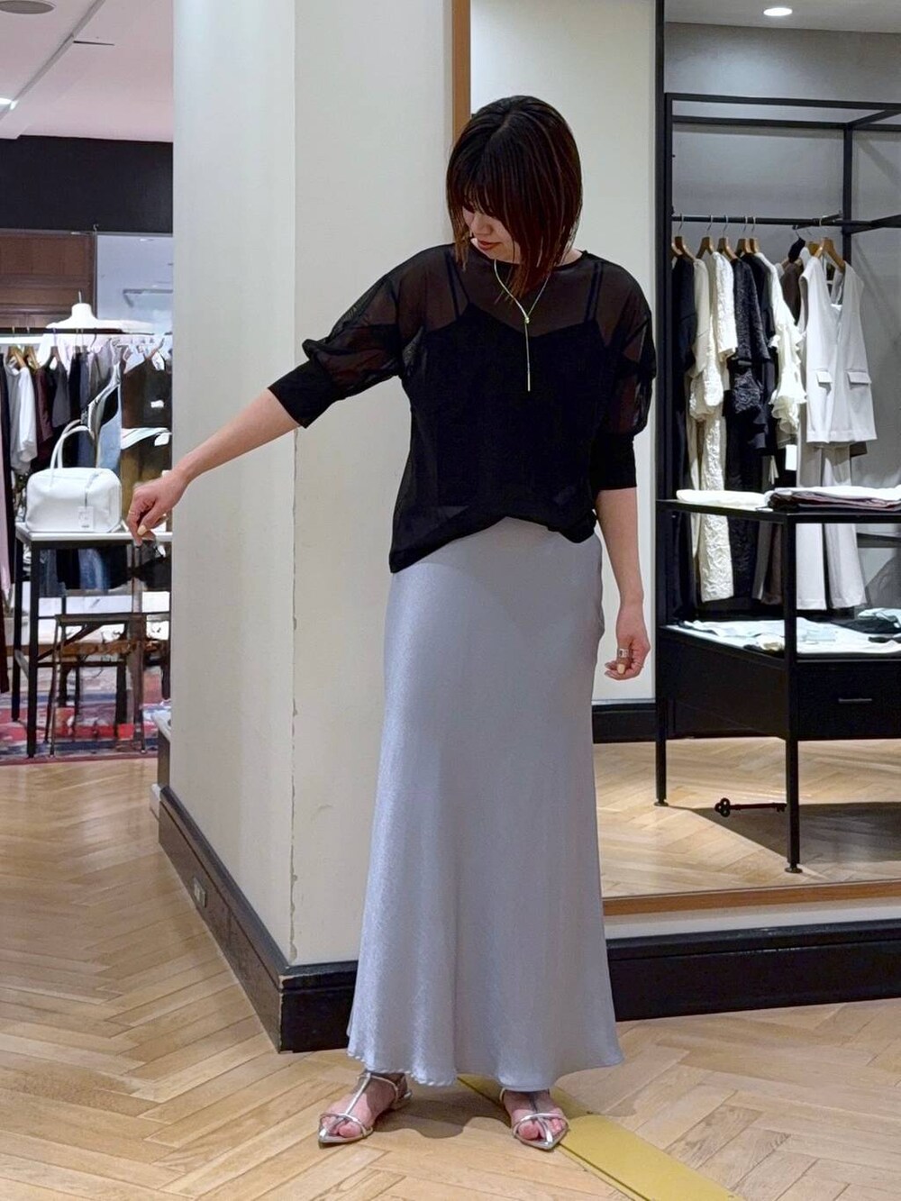 ブルー系のスカート、ブラック系のTシャツ/カットソー、ブラック系のキャミソールを着用したレディースの夏コーディネートの2枚目の写真