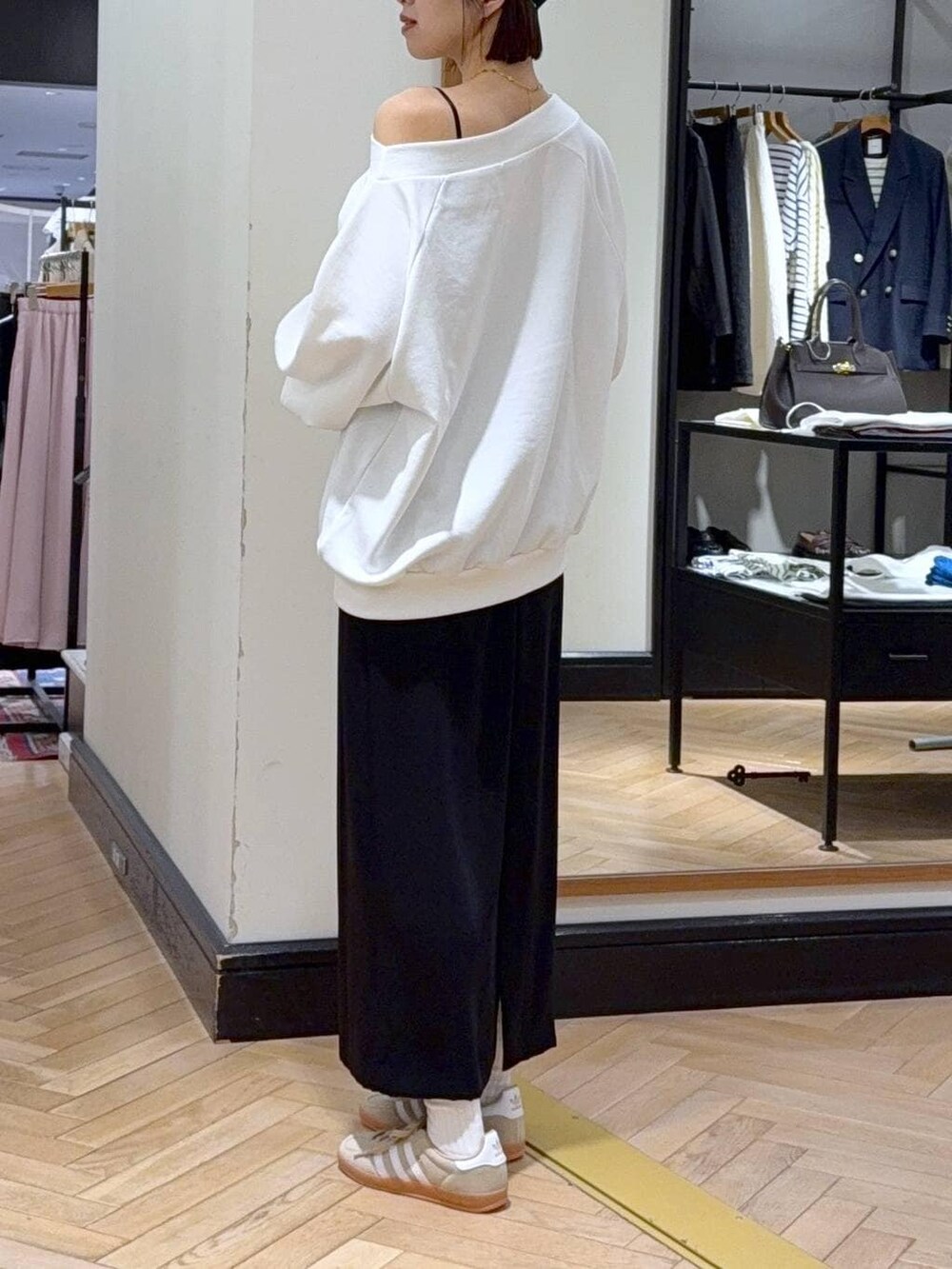 ベージュ系のスニーカー、ブラック系のショルダーバッグ、ホワイト系のスウェットを着用したレディースの冬コーディネートの4枚目の写真