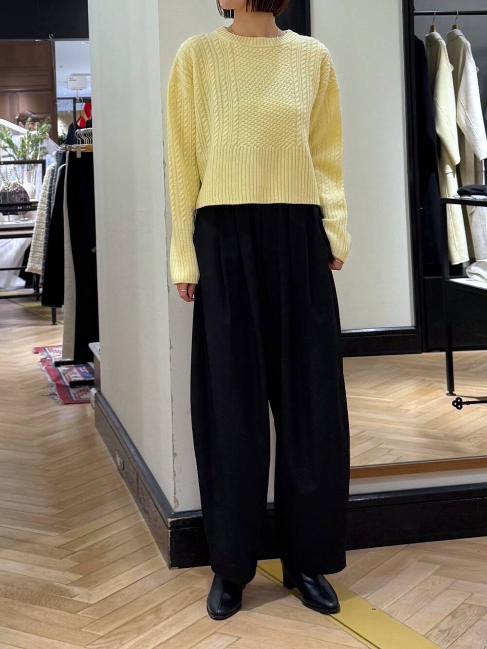 ブラック系のスラックス、ブラック系のブーツ、ブラック系のショルダーバッグを着用したレディースの冬コーディネートの4枚目の写真