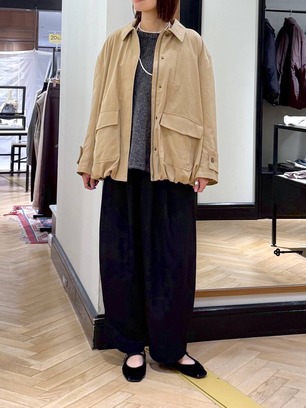 ブラック系のスラックス、グレー系のニット/セーター、ブラック系のショルダーバッグを着用したレディースの秋コーディネートの2枚目の写真