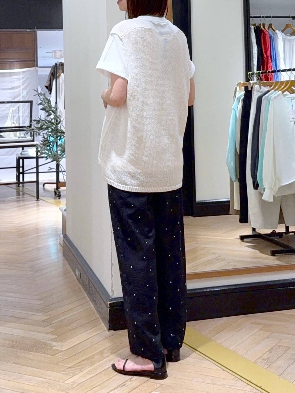 ホワイト系のニット/セーター、ホワイト系のTシャツ/カットソー、ブラック系のサンダルを着用したレディースの春コーディネートの3枚目の写真