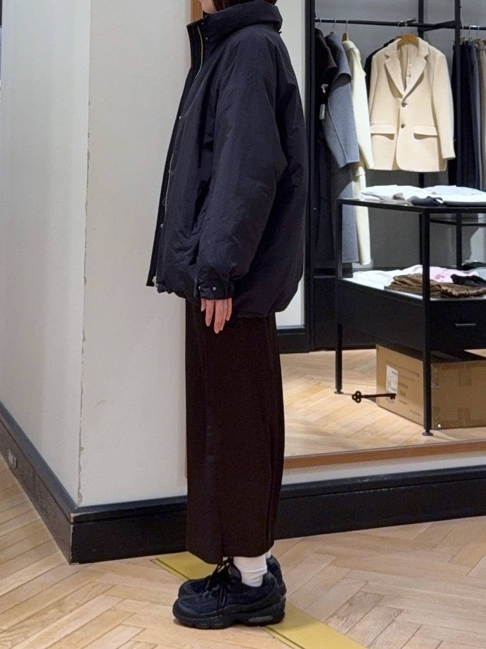 ブラック系のブルゾン、グレー系のニット/セーター、ブラウン系のスカートを着用したレディースの冬コーディネートの2枚目の写真