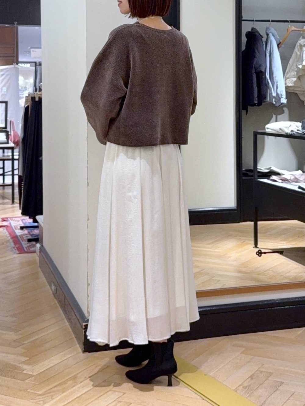 ブラウン系のニット/セーター、ブラック系のブルゾン、ブラック系のブーツを着用したレディースの秋コーディネートの9枚目の写真