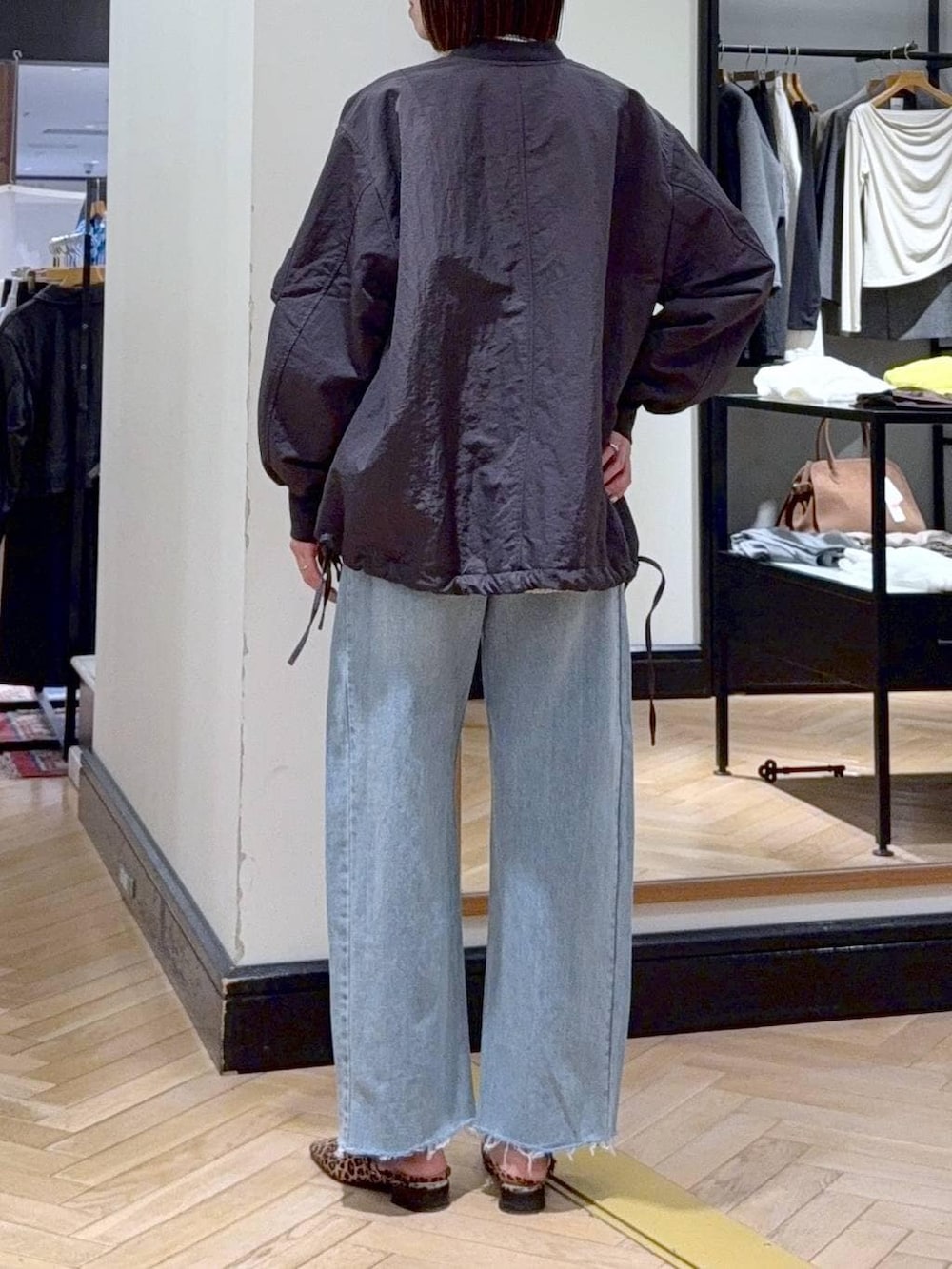 グレー系のMA-1、ブルー系のデニムパンツ、ブラック系のショルダーバッグを着用したレディースの春コーディネートの5枚目の写真