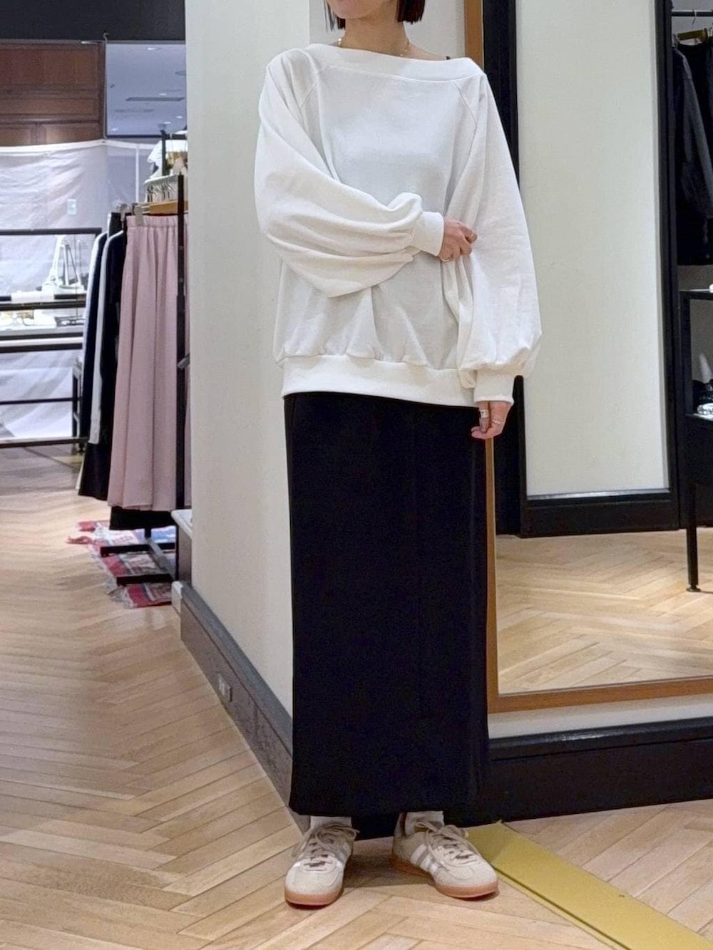 ベージュ系のスニーカー、ブラック系のショルダーバッグ、ホワイト系のスウェットを着用したレディースの冬コーディネートの2枚目の写真