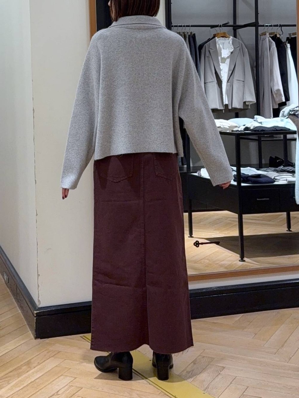 ホワイト系のTシャツ/カットソー、ブラック系のブーツ、レッド系のデニムスカートを着用したレディースの秋コーディネートの6枚目の写真