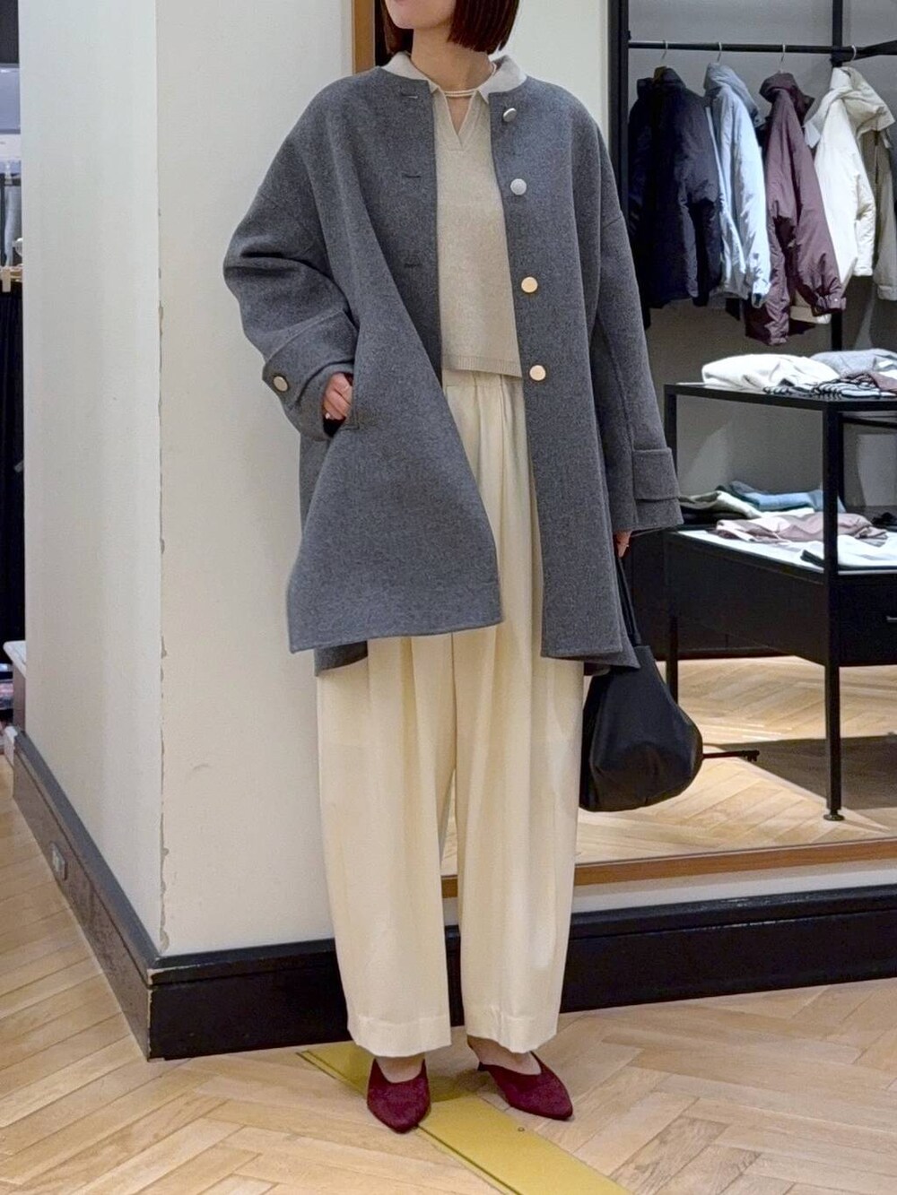 ホワイト系のスラックス、レッド系のパンプス、ブラック系のショルダーバッグを着用したレディースの秋コーディネートの7枚目の写真