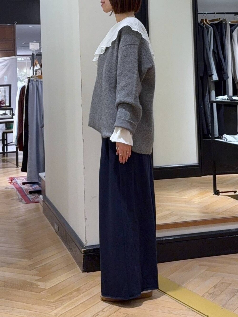 グレー系のカーディガン/ボレロ、ホワイト系のシャツ/ブラウス、ブルー系のスウェットパンツを着用したレディースの秋コーディネートの2枚目の写真