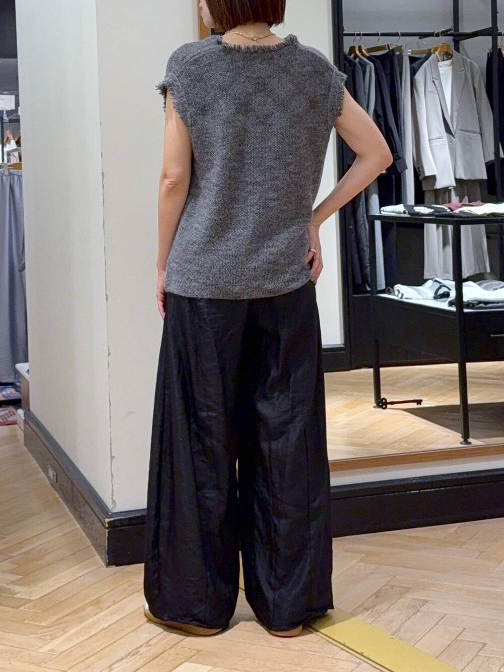 グレー系のベスト、ブラック系のその他パンツ、ブラック系のショルダーバッグを着用したレディースの秋コーディネートの4枚目の写真
