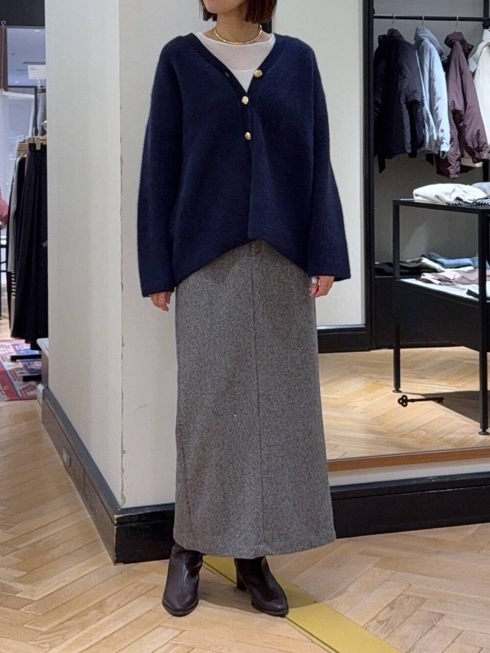 ブルー系のカーディガン/ボレロ、ホワイト系のTシャツ/カットソー、ブラック系のブーツを着用したレディースの秋コーディネートの6枚目の写真