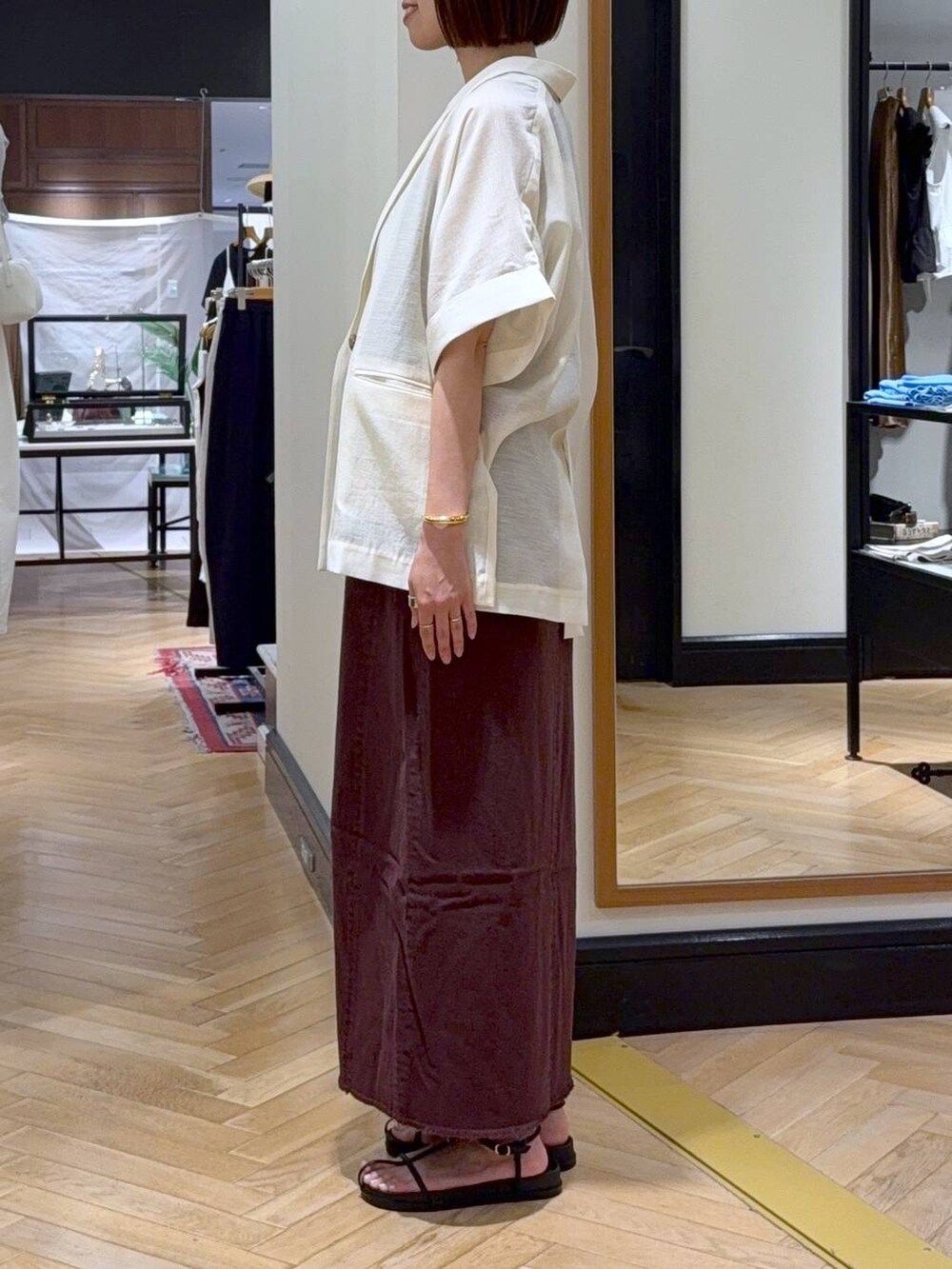 シルバー系のハンドバッグ、レッド系のワンピース、ホワイト系のサンダルを着用したレディースの夏コーディネートの2枚目の写真