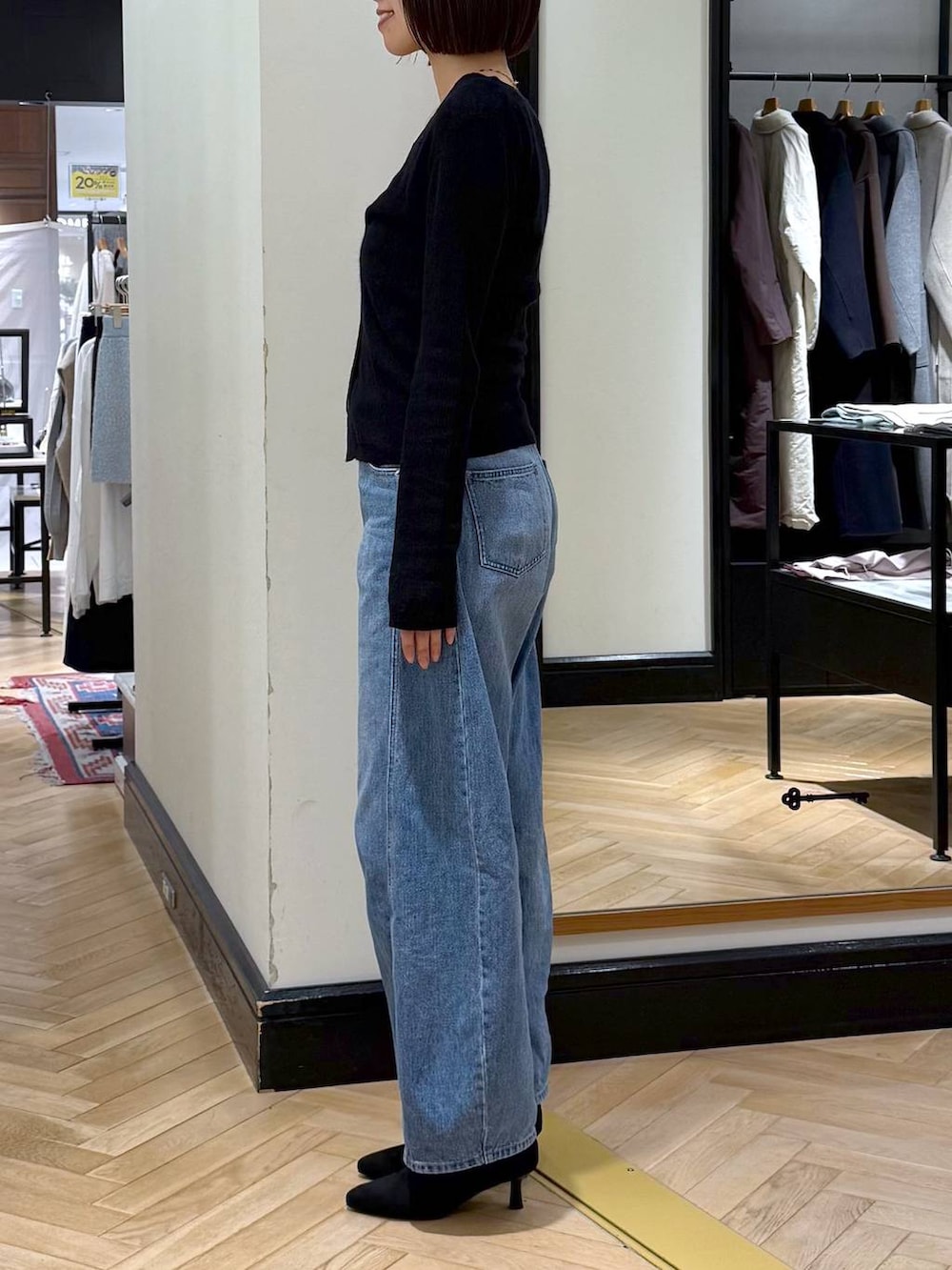 ブルー系のデニムパンツ、ブラック系のブーツ、ブラック系のカーディガン/ボレロを着用したレディースの秋コーディネートの2枚目の写真