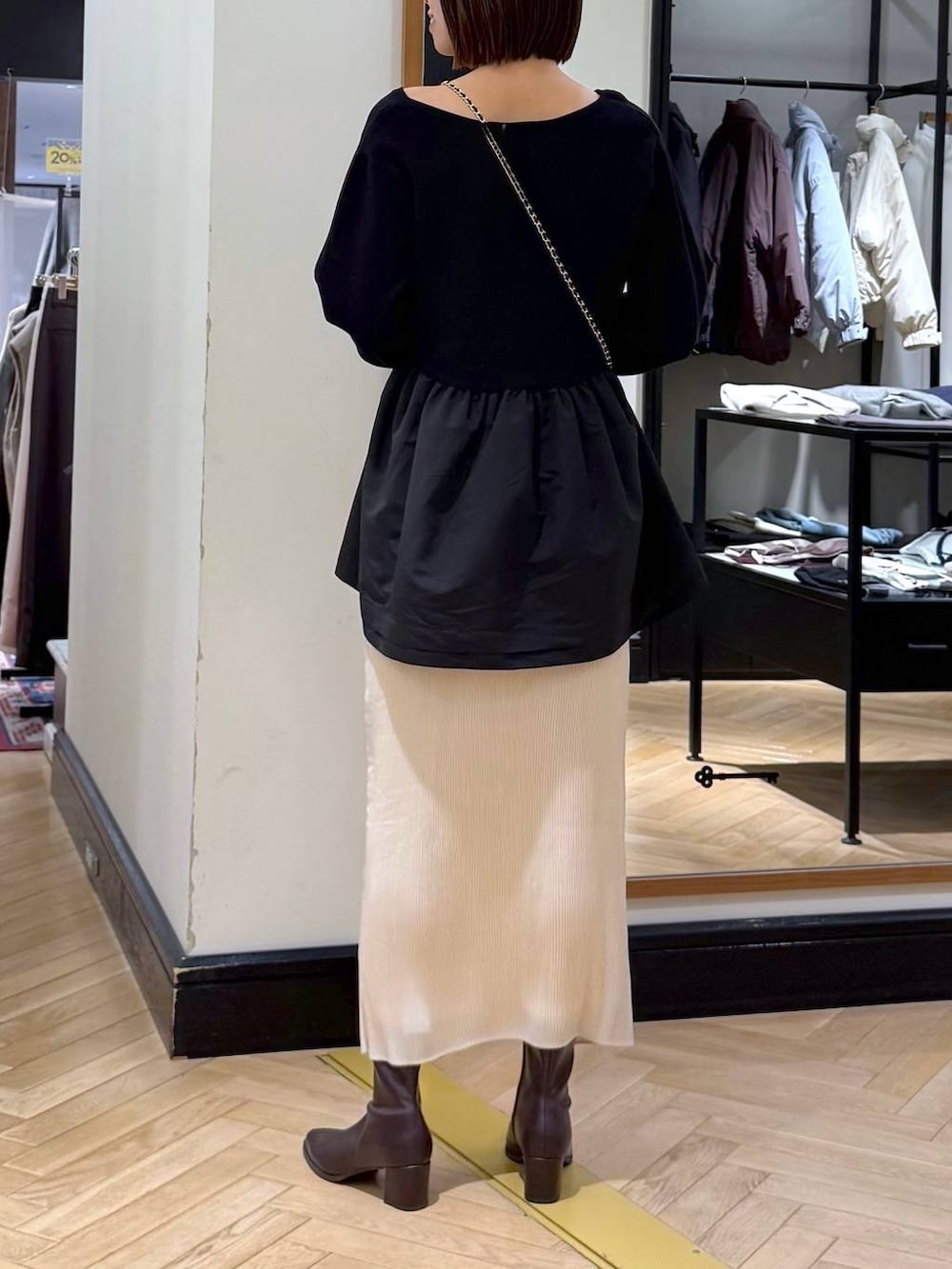 ブラウン系のブーツ、ホワイト系のスカート、ブラック系のニット/セーターを着用したレディースの秋コーディネートの4枚目の写真