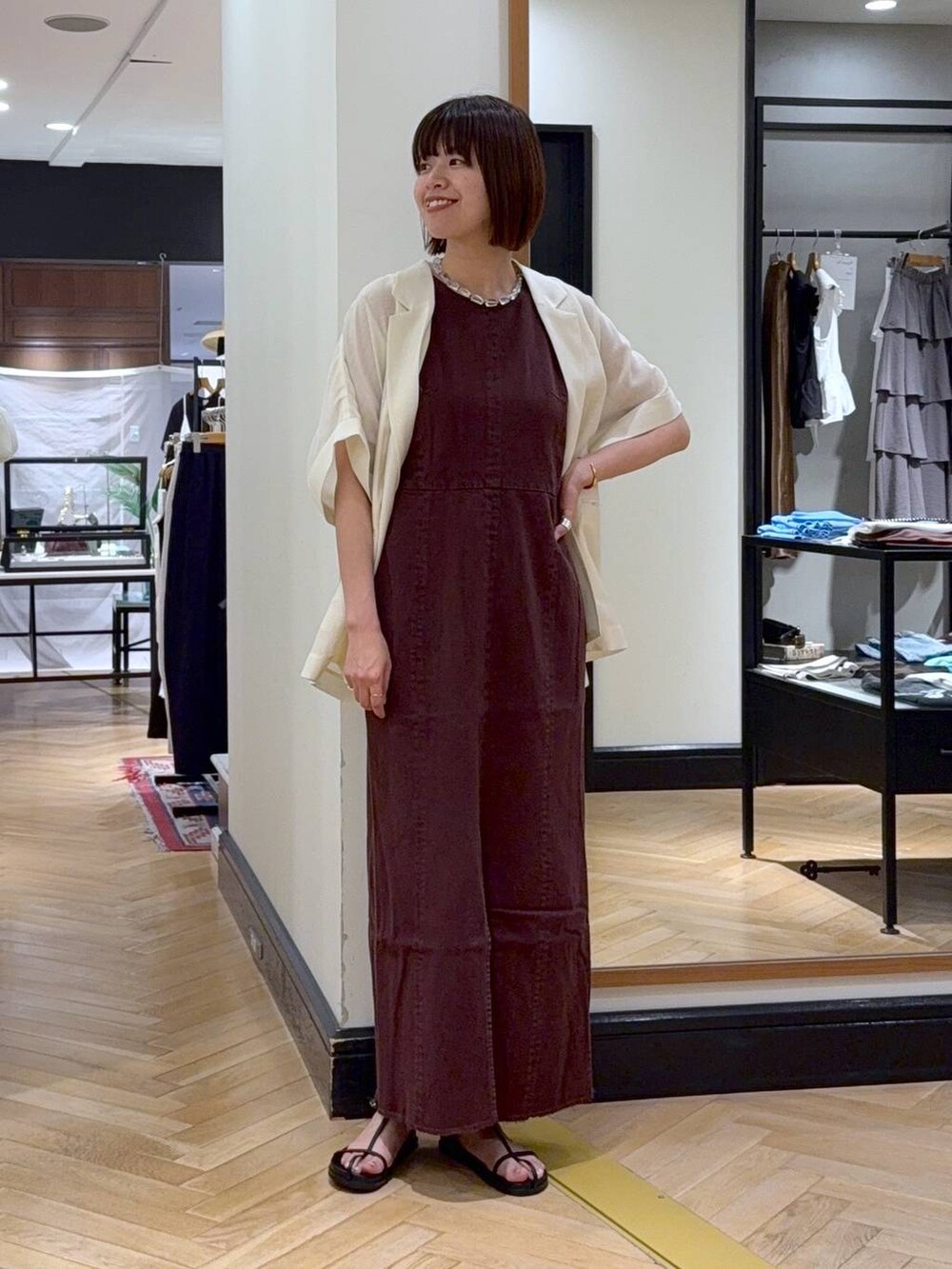 シルバー系のハンドバッグ、レッド系のワンピース、ホワイト系のサンダルを着用したレディースの夏コーディネートの5枚目の写真