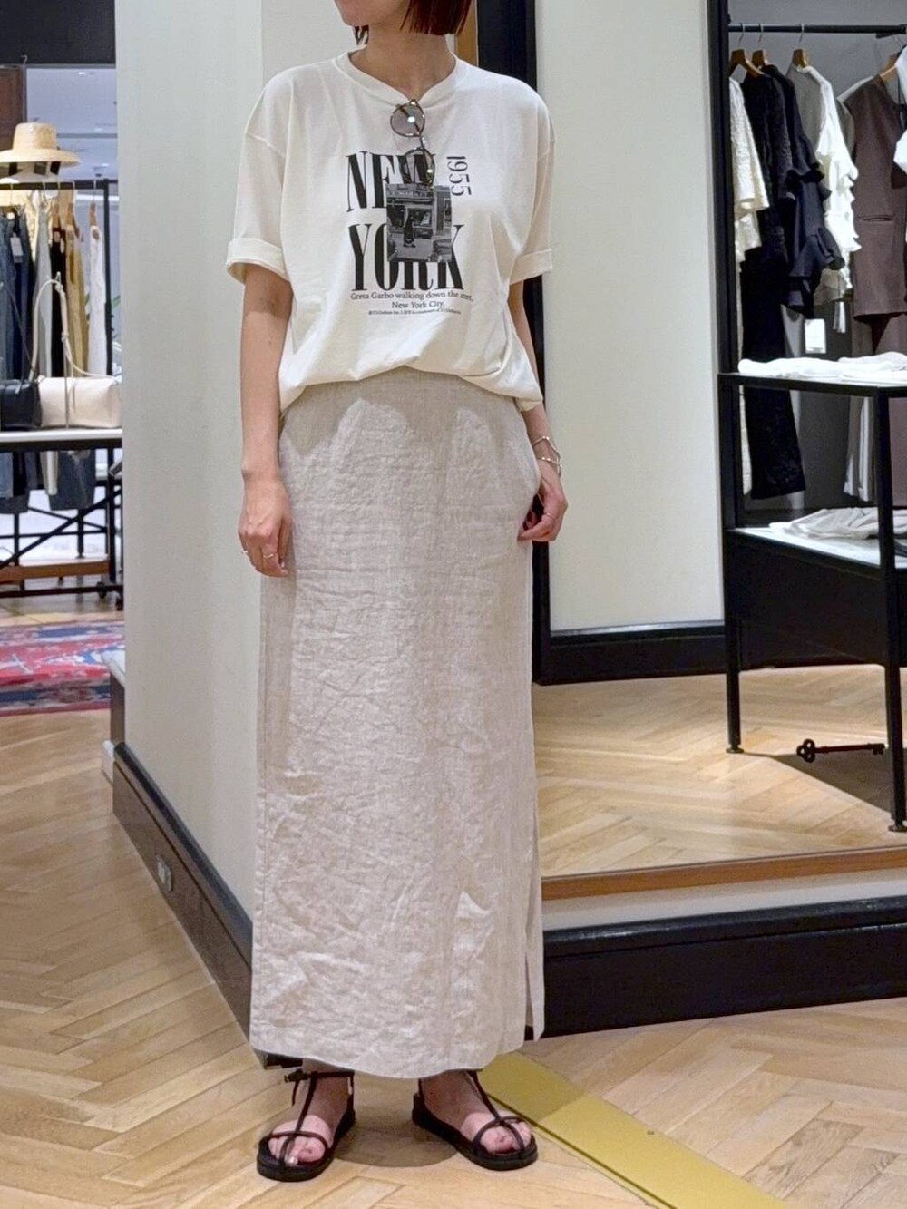 ホワイト系のショルダーバッグ、ホワイト系のTシャツ/カットソー、ブラック系のサンダルを着用したレディースの夏コーディネートの4枚目の写真