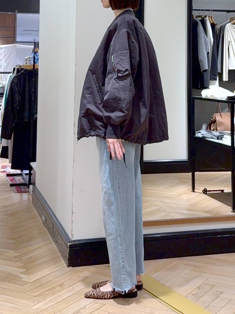 グレー系のMA-1、ブルー系のデニムパンツ、ブラック系のショルダーバッグを着用したレディースの春コーディネートの3枚目の写真