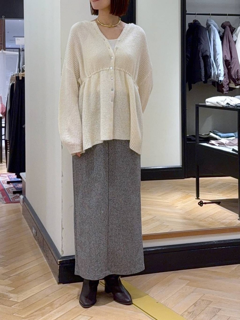 ブラウン系のブーツ、ブラック系のショルダーバッグ、ブラック系のスカートを着用したレディースの秋コーディネートの6枚目の写真