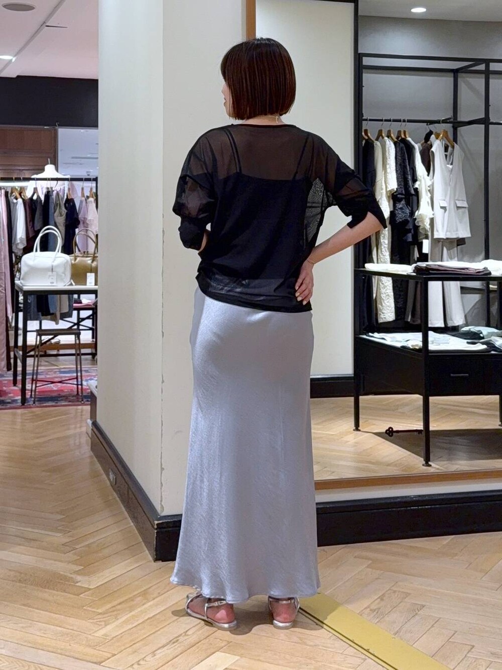 ブルー系のスカート、ブラック系のTシャツ/カットソー、ブラック系のキャミソールを着用したレディースの夏コーディネートの4枚目の写真