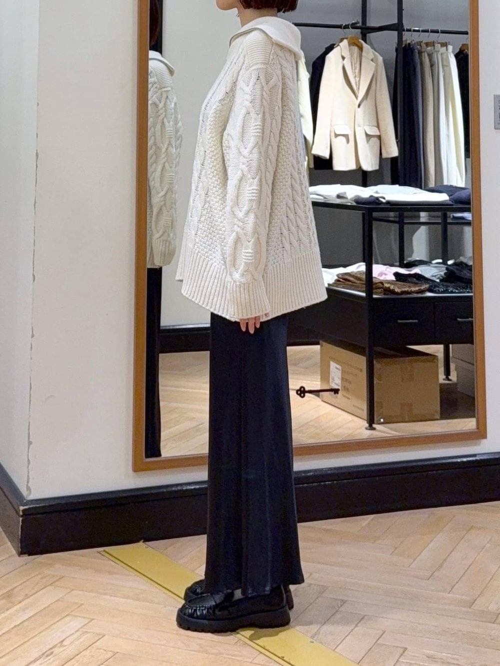 ブルー系のスカート、ベージュ系のショルダーバッグ、ホワイト系のニット/セーターを着用したレディースの冬コーディネートの2枚目の写真