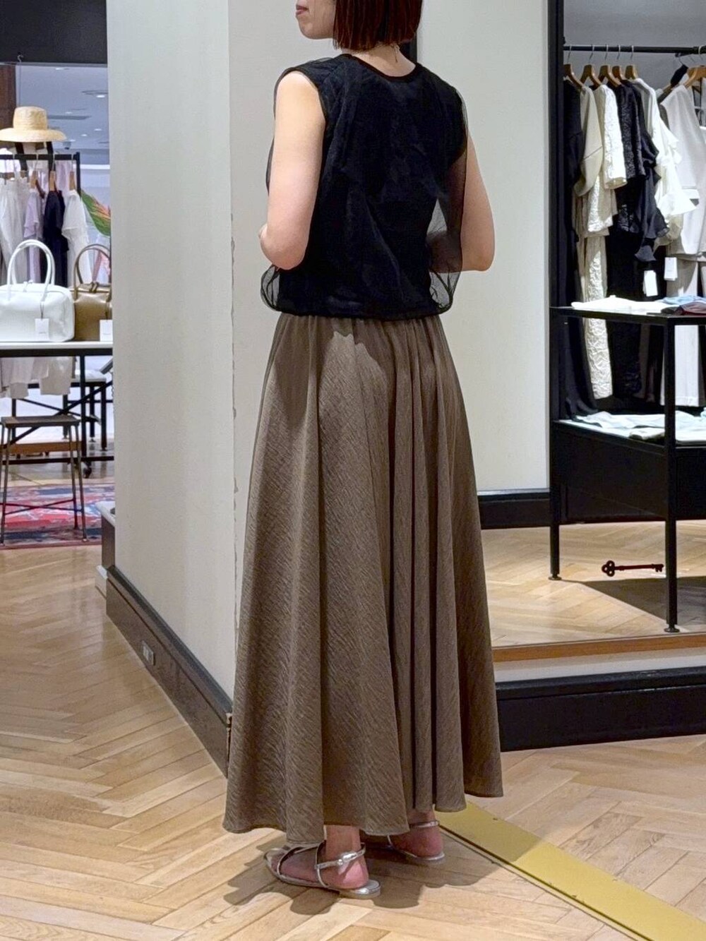 シルバー系のサンダル、ブラック系のニット/セーター、グリーン系のスカートを着用したレディースの夏コーディネートの3枚目の写真