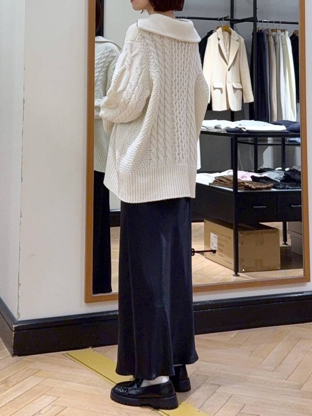 ブルー系のスカート、ベージュ系のショルダーバッグ、ホワイト系のニット/セーターを着用したレディースの冬コーディネートの3枚目の写真