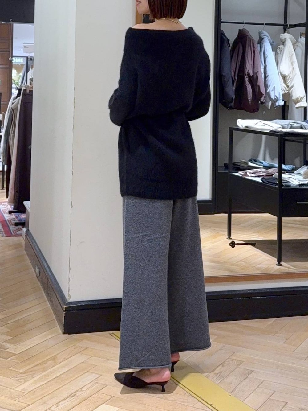 ブラック系のワンピース、ブラウン系のパンプス、ブラック系のショルダーバッグを着用したレディースの秋コーディネートの3枚目の写真