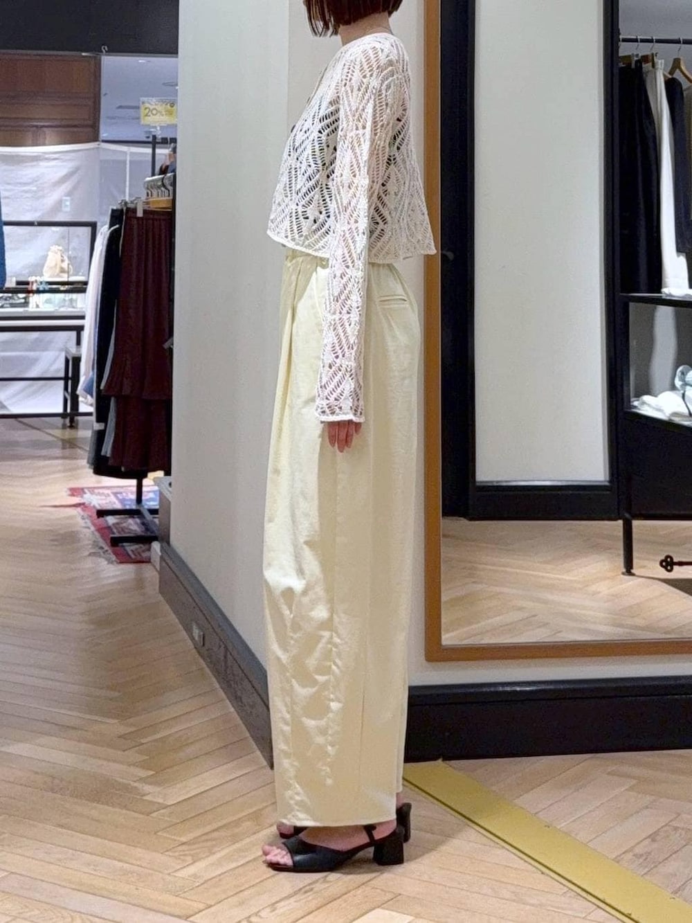 ホワイト系のショルダーバッグ、ホワイト系のカーディガン/ボレロ、ブラック系のサンダルを着用したレディースの春コーディネートの3枚目の写真