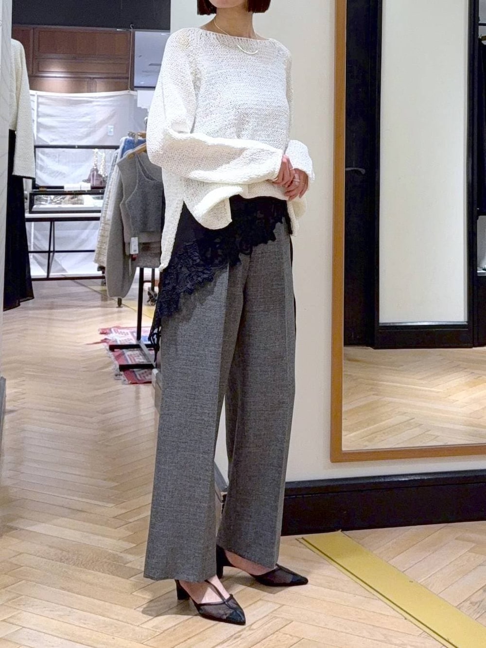 グリーン系のショルダーバッグ、ブラック系のスラックス、ブラック系のパンプスを着用したレディースの冬コーディネートの2枚目の写真