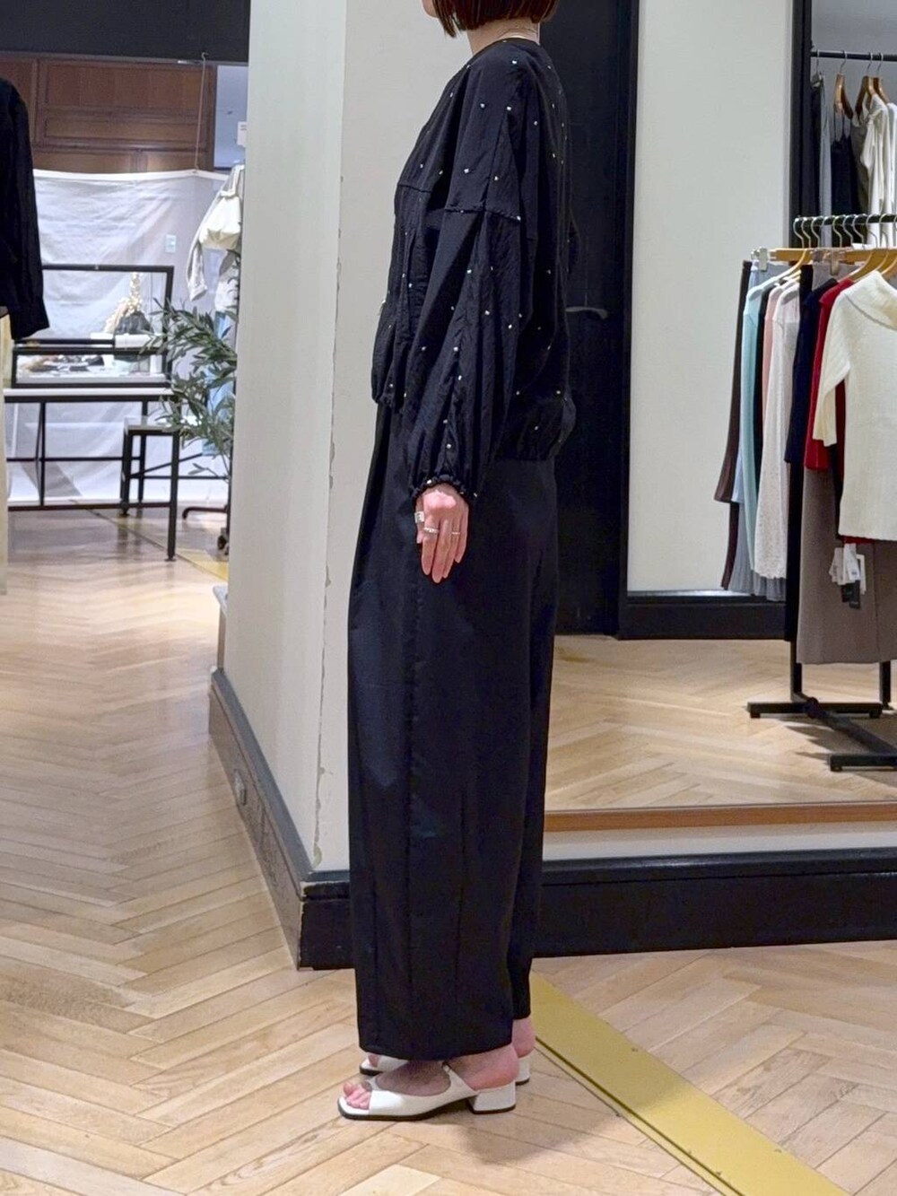 ホワイト系のショルダーバッグ、イエロー系のタンクトップ、ホワイト系のパンプスを着用したレディースの春コーディネートの3枚目の写真