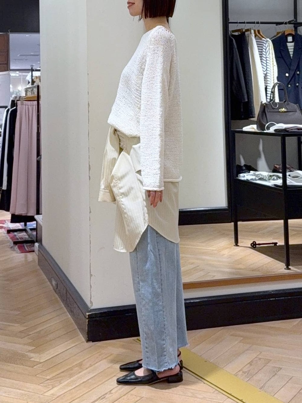 ブルー系のデニムパンツ、ホワイト系のニット/セーター、イエロー系のシャツ/ブラウスを着用したレディースの冬コーディネートの2枚目の写真