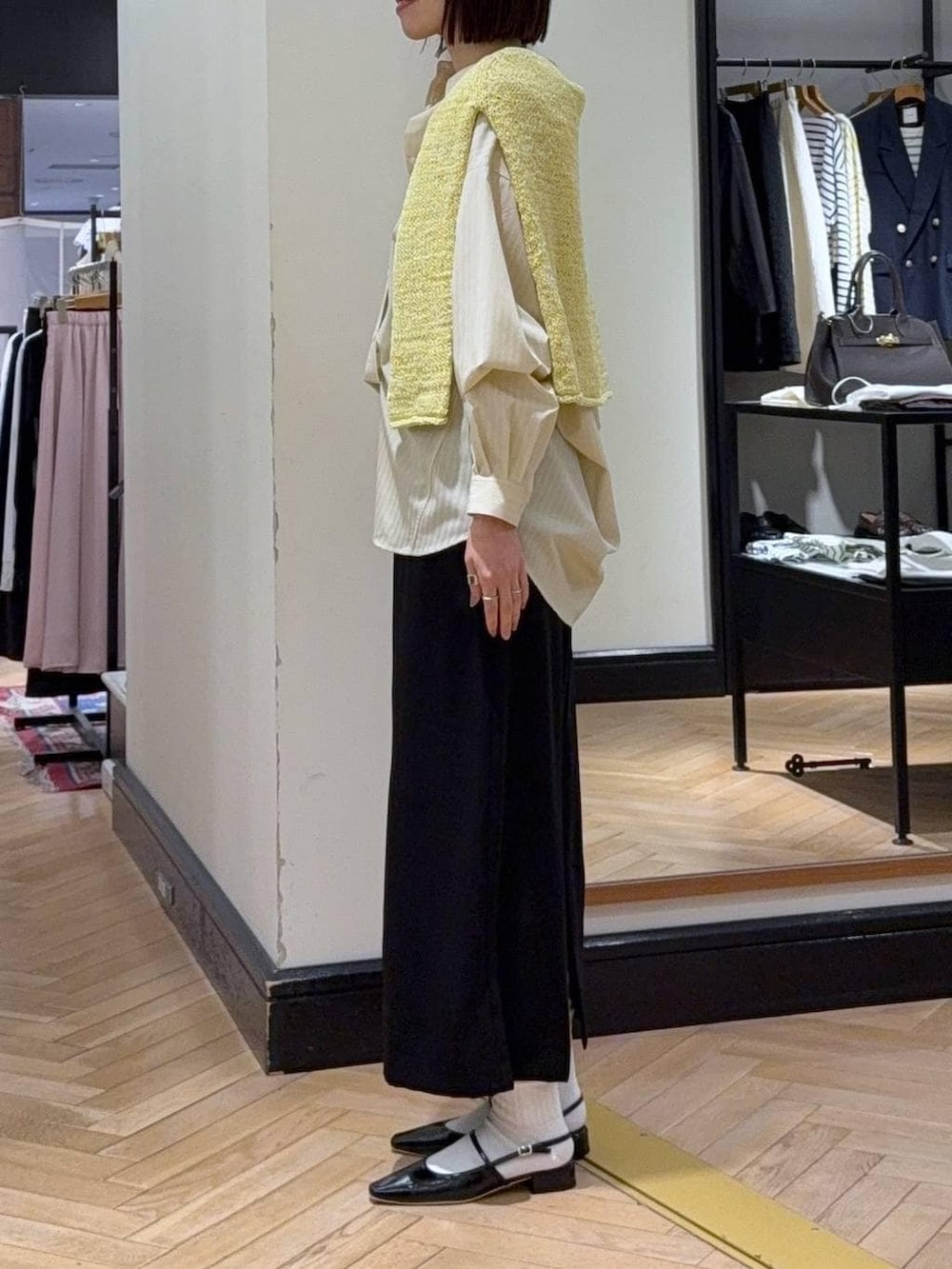 ブラック系のショルダーバッグ、イエロー系のニット/セーター、イエロー系のシャツ/ブラウスを着用したレディースの冬コーディネートの2枚目の写真