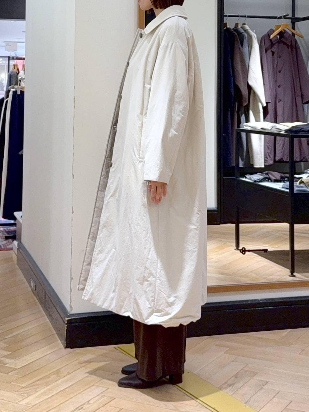 ブラック系のブーツ、グレー系のニット/セーター、ブラウン系のスラックスを着用したレディースの冬コーディネートの2枚目の写真