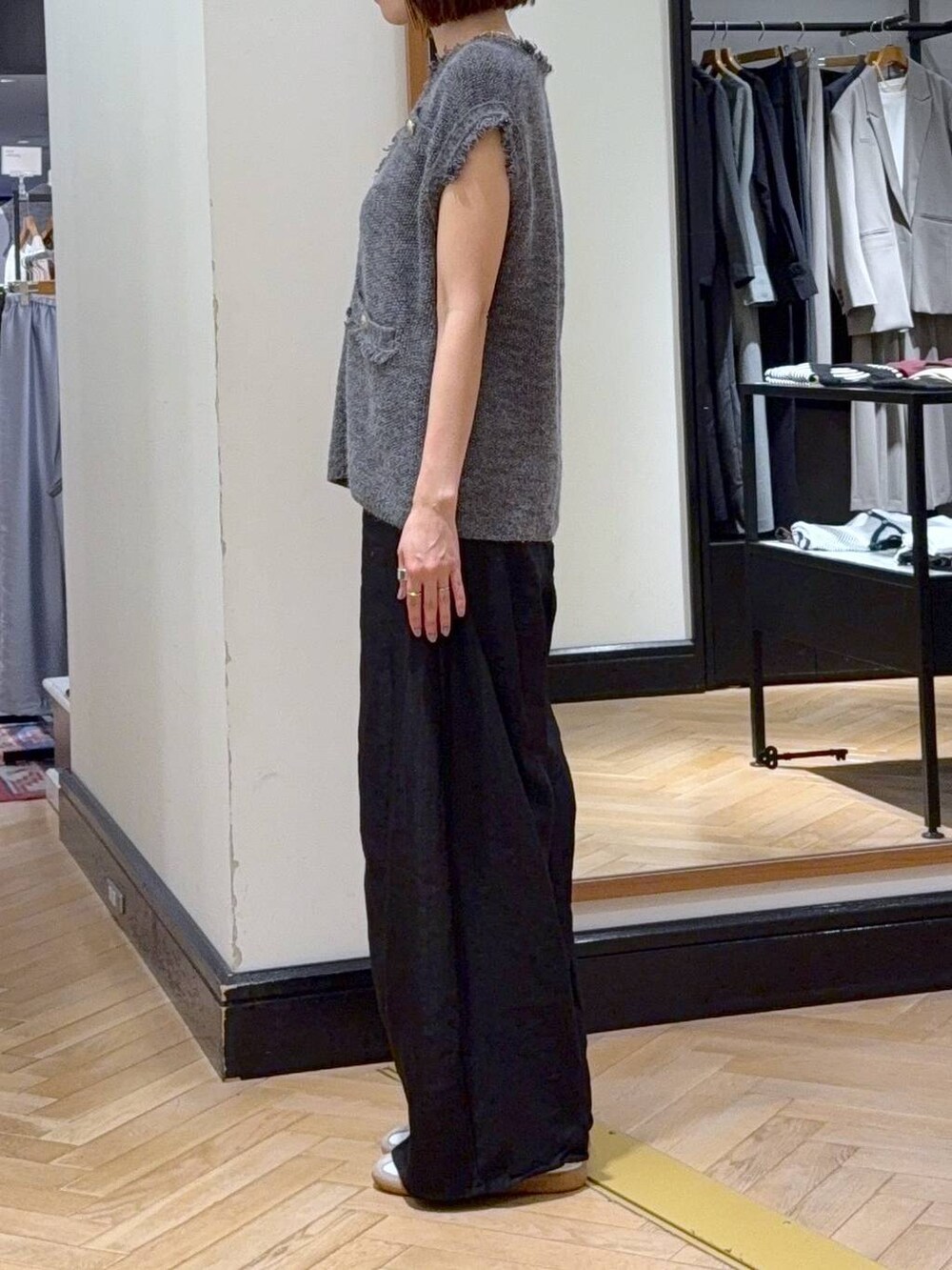グレー系のベスト、ブラック系のその他パンツ、ブラック系のショルダーバッグを着用したレディースの秋コーディネートの2枚目の写真