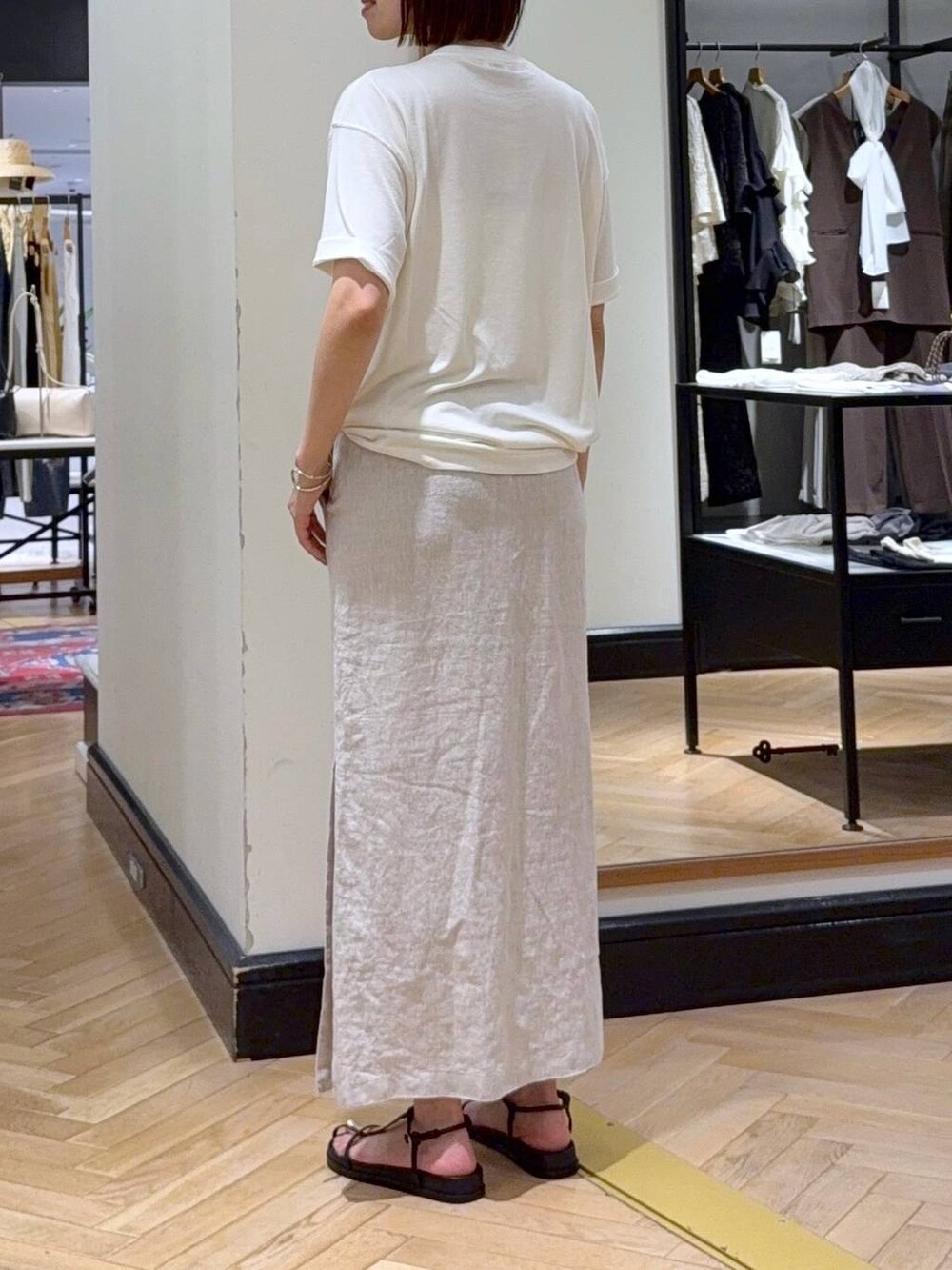 ホワイト系のショルダーバッグ、ホワイト系のTシャツ/カットソー、ブラック系のサンダルを着用したレディースの夏コーディネートの3枚目の写真