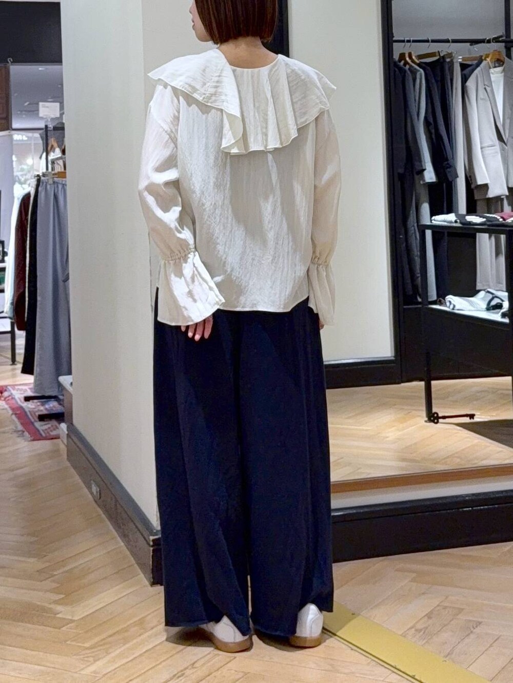 ブラック系のショルダーバッグ、ホワイト系のシャツ/ブラウス、ブルー系のスウェットパンツを着用したレディースの秋コーディネートの5枚目の写真