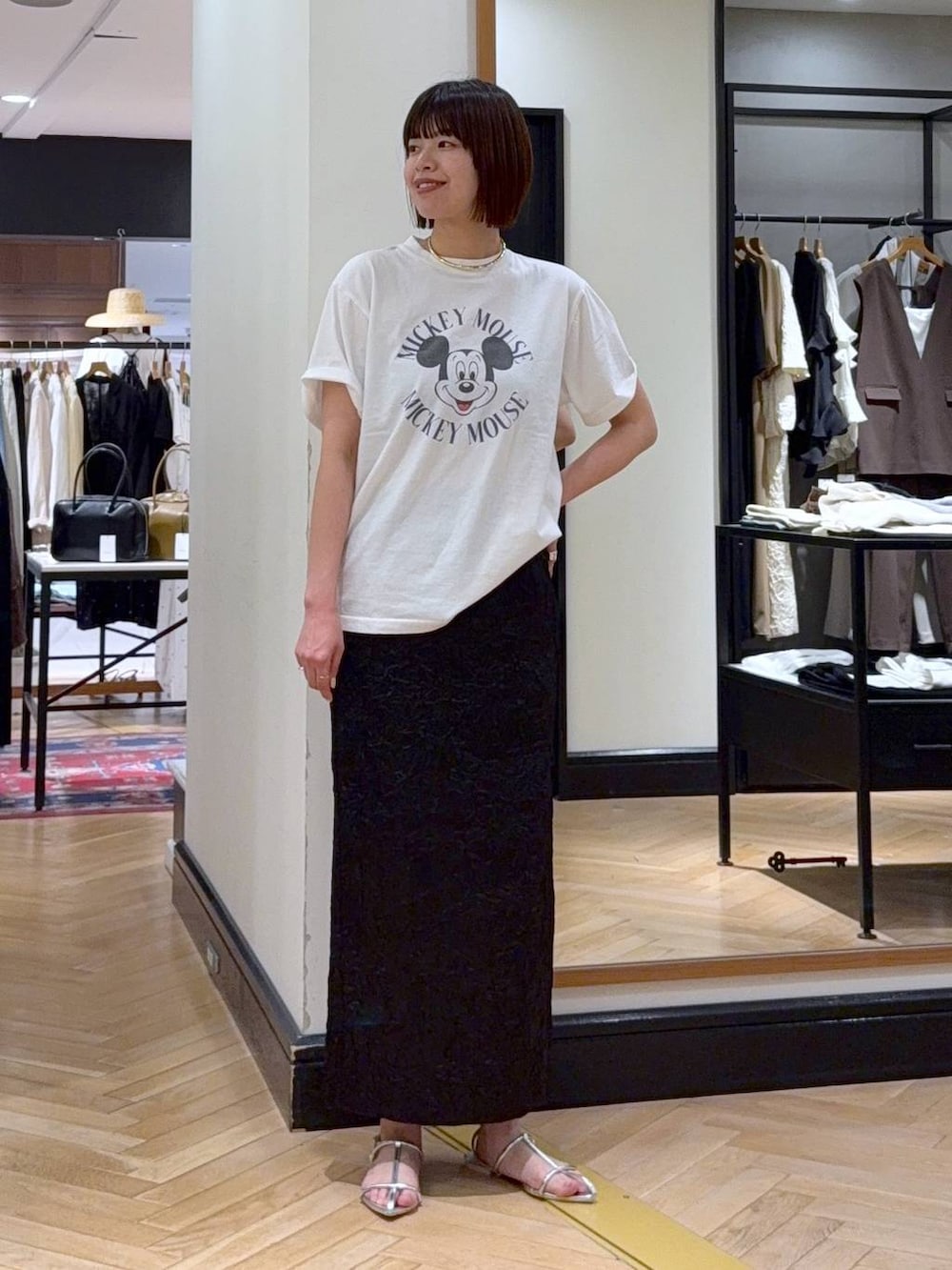 ホワイト系のTシャツ/カットソー、シルバー系のサンダル、ブラック系のワンピースを着用したレディースの夏コーディネートの2枚目の写真