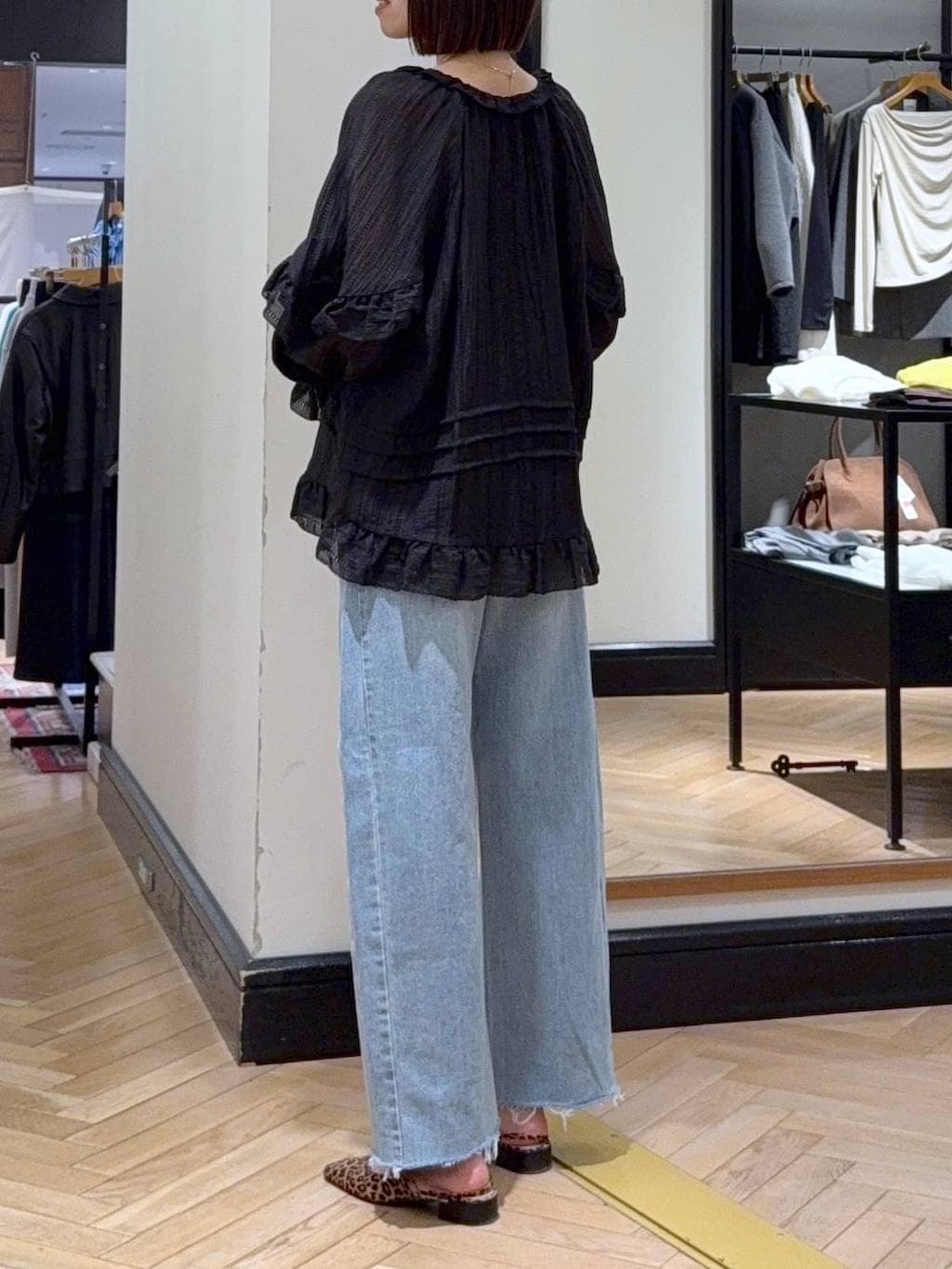 ブルー系のデニムパンツ、ブラック系のシャツ/ブラウス、ブラウン系のパンプスを着用したレディースの春コーディネートの4枚目の写真