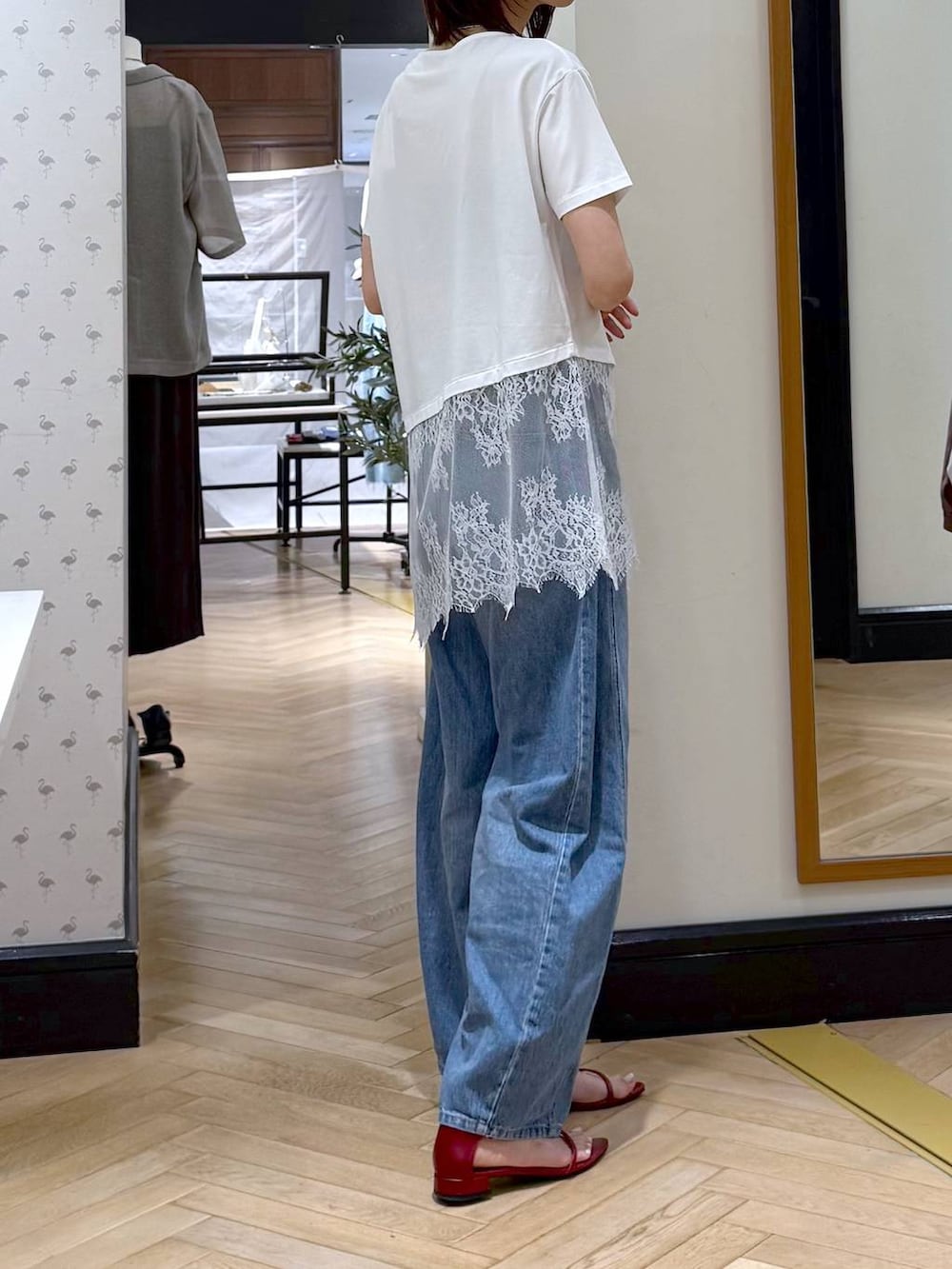 ブルー系のデニムパンツ、レッド系のサンダル、ホワイト系のTシャツ/カットソーを着用したレディースの夏コーディネートの2枚目の写真
