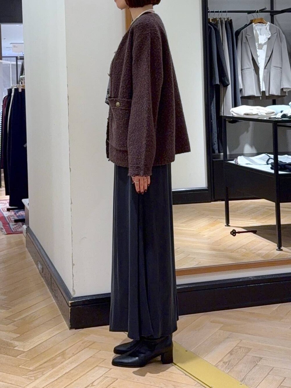 ブラック系のブーツ、ブラウン系のカーディガン/ボレロ、ブラック系のスカートを着用したレディースの秋コーディネートの3枚目の写真