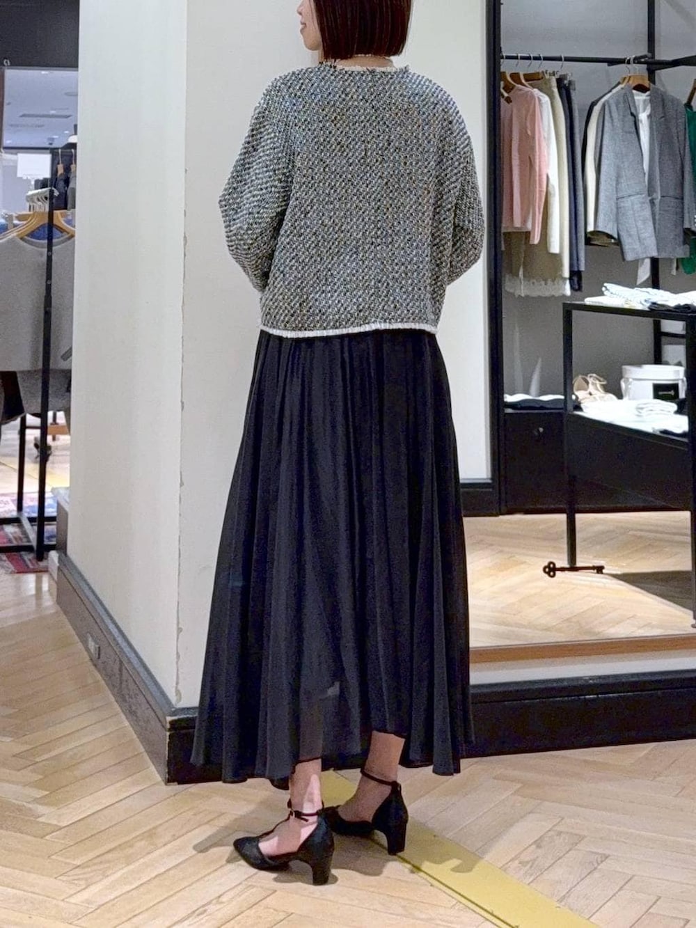 ブラック系のスカート、ブラック系のノーカラージャケット、ブラック系のパンプスを着用したレディースの冬コーディネートの5枚目の写真