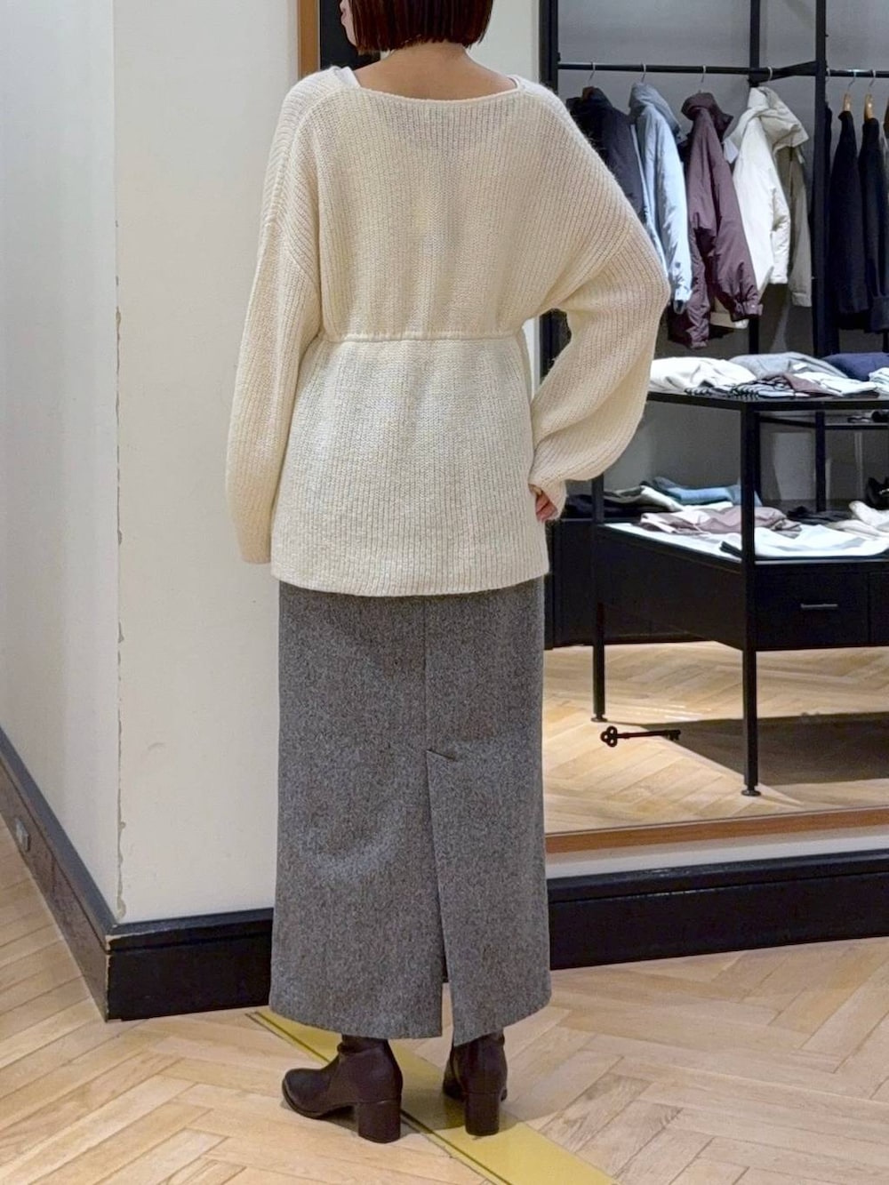 ブラウン系のブーツ、ブラック系のショルダーバッグ、ブラック系のスカートを着用したレディースの秋コーディネートの5枚目の写真