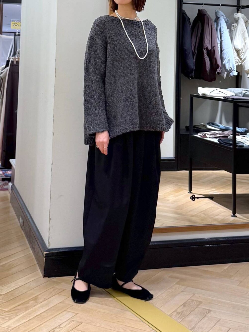 ブラック系のスラックス、グレー系のニット/セーター、ブラック系のショルダーバッグを着用したレディースの秋コーディネートの5枚目の写真