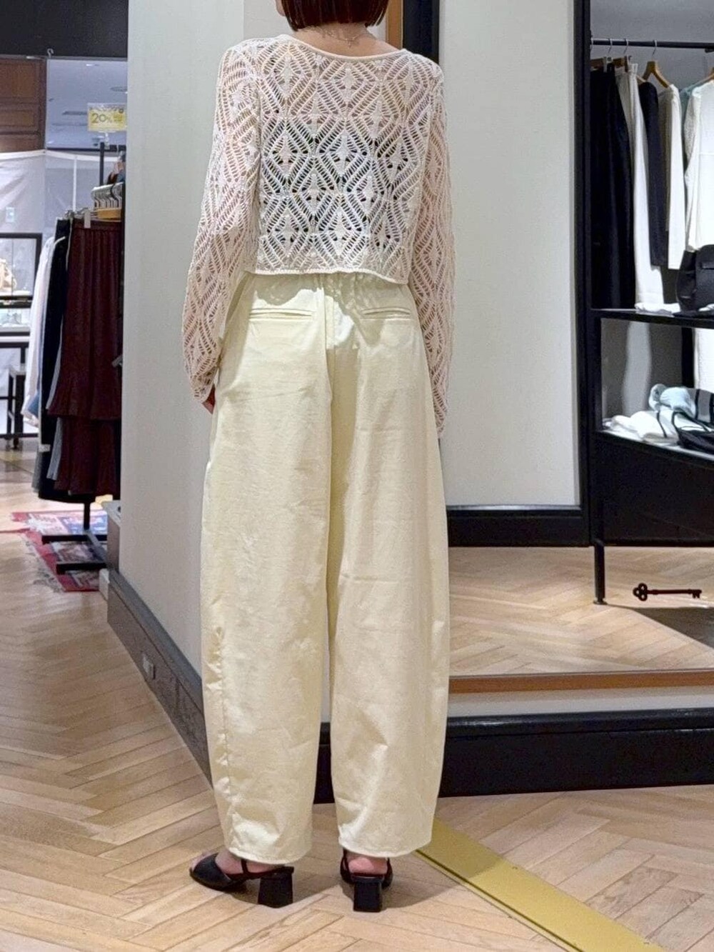 ホワイト系のショルダーバッグ、ホワイト系のカーディガン/ボレロ、ブラック系のサンダルを着用したレディースの春コーディネートの5枚目の写真