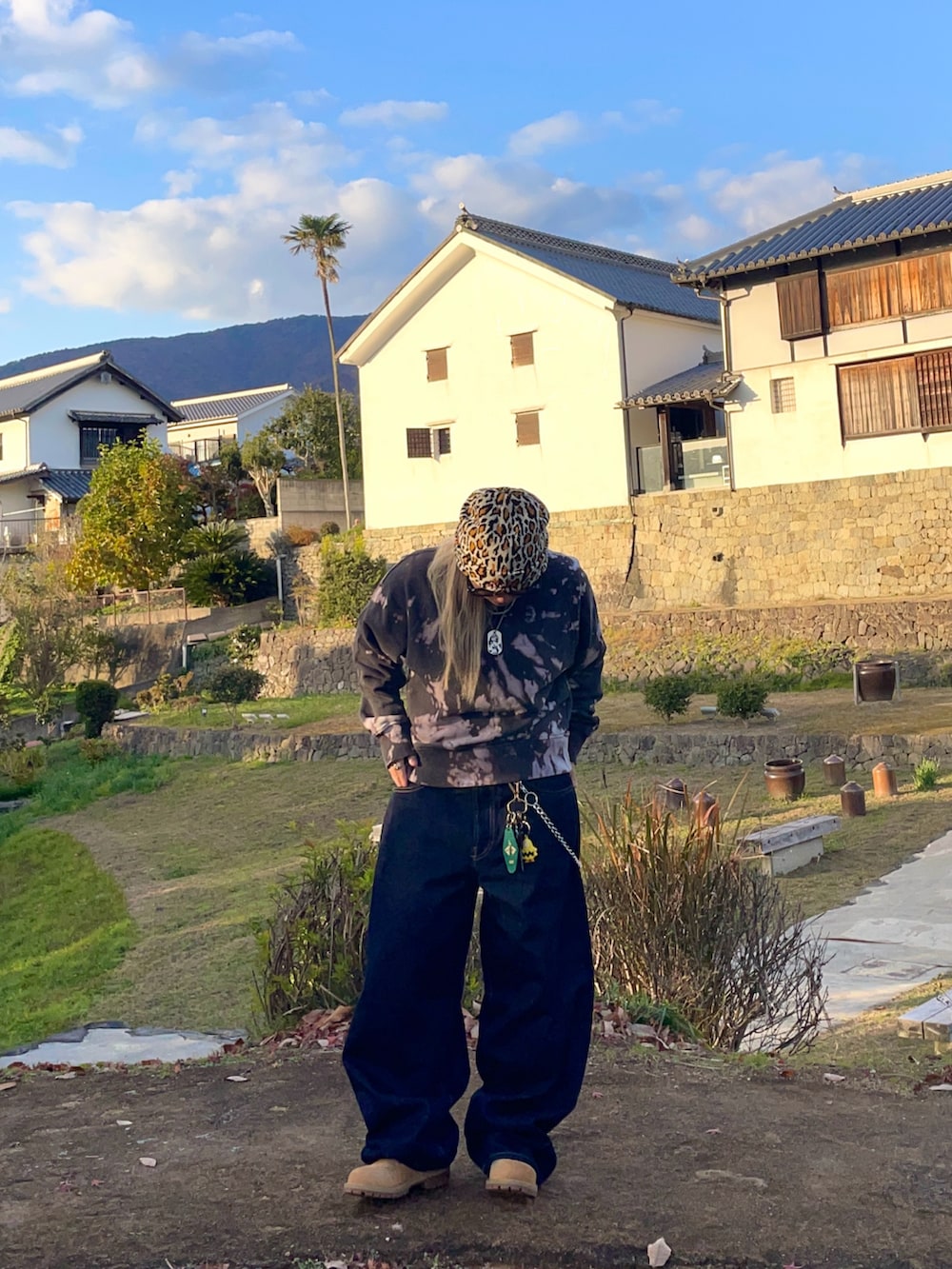 イエロー系のブーツ、ブルー系のデニムパンツ、ブラック系のスウェットを着用したレディースの春コーディネートの3枚目の写真