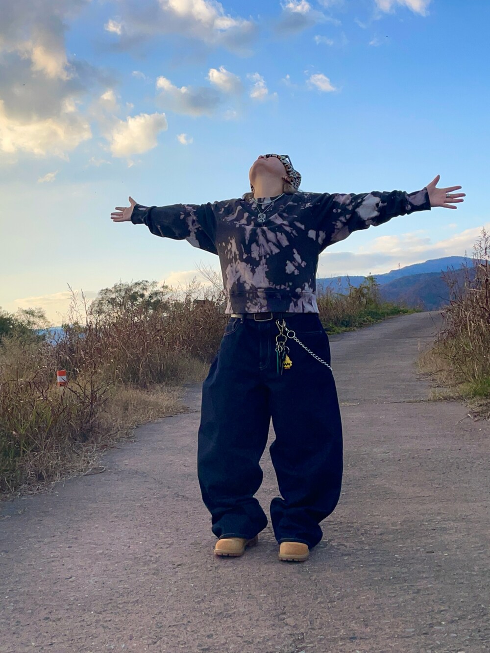 イエロー系のブーツ、ブルー系のデニムパンツ、ブラック系のスウェットを着用したレディースの春コーディネートの2枚目の写真