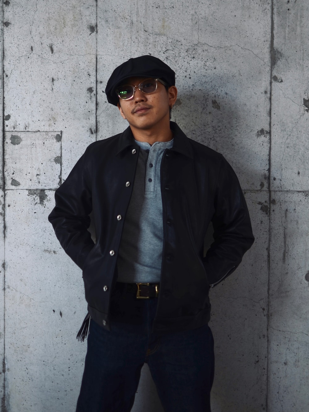 ブラック系のライダースジャケット、ブルー系のデニムパンツを着用したメンズの秋コーディネートの2枚目の写真