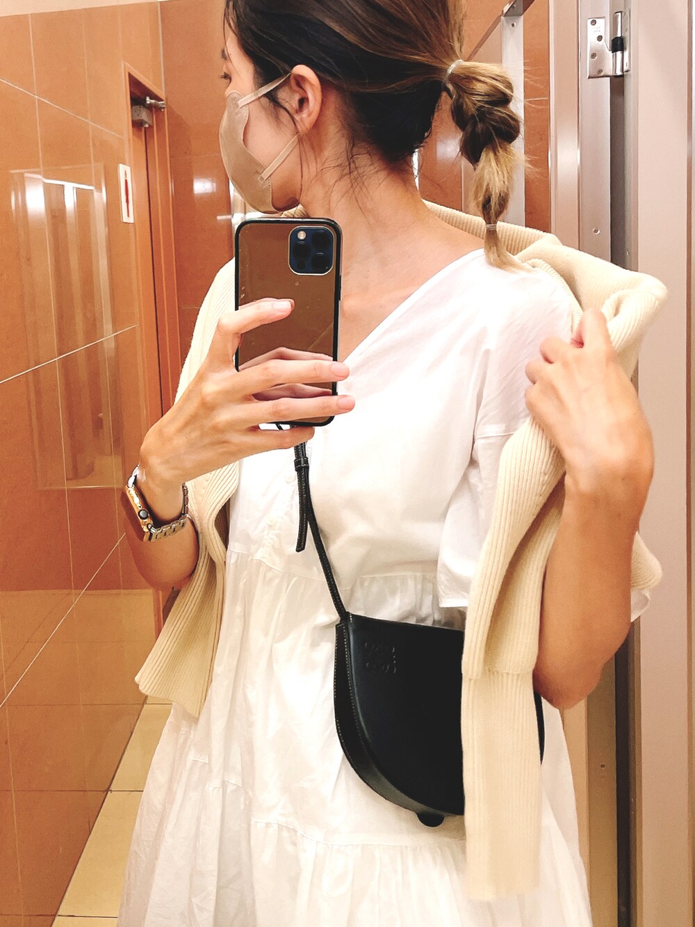 ブラック系のサンダル、ホワイト系のカーディガン/ボレロ、ブラック系のショルダーバッグを着用したレディースの秋コーディネートの2枚目の写真