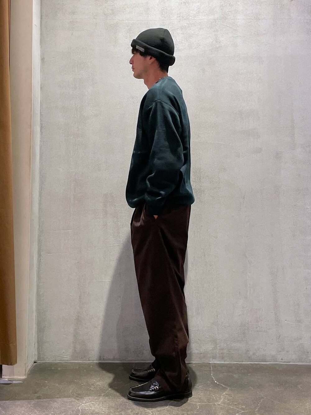 ブラウン系のその他パンツ、ブラック系のローファー、グリーン系のニット/セーターを着用したメンズの冬コーディネートの2枚目の写真