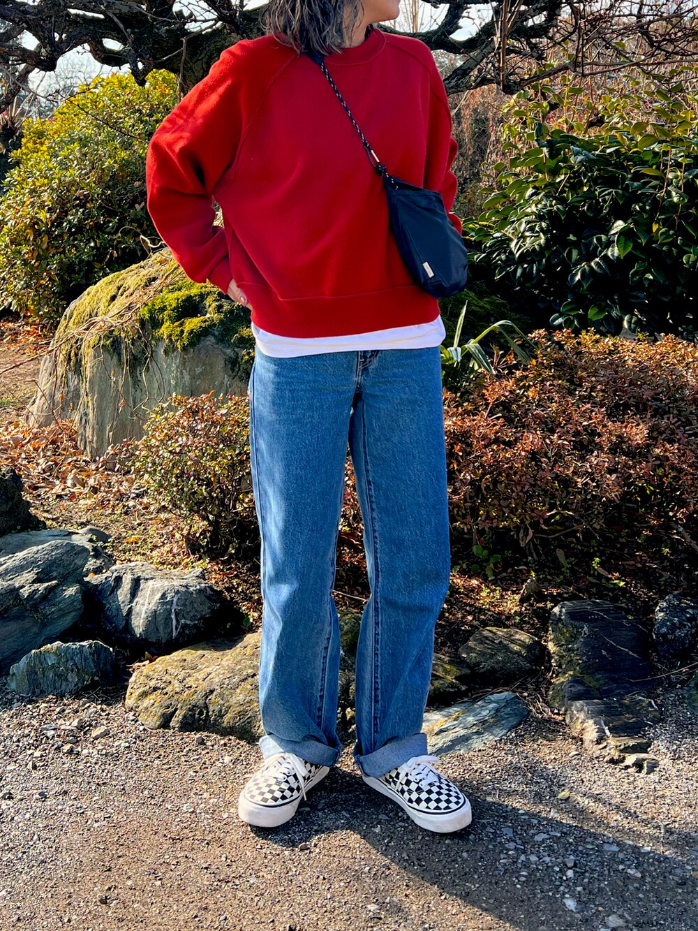 その他のスニーカー、ブルー系のデニムパンツ、レッド系のニット/セーターを着用したレディースの冬コーディネートの2枚目の写真